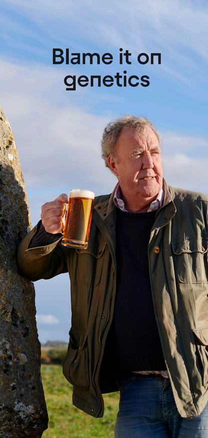 Man holding a mug of beer standing next to stone circles with text 'Blame it on genetics' above.